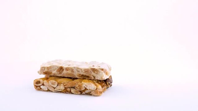 半框切割传统西班牙甜点Turron。在白色背景上旋转。孤立。特写宏。可循环。