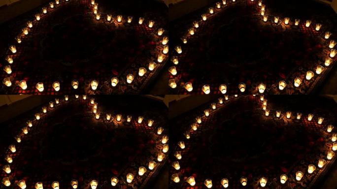 火热的心。蜡烛排列成心形。背景动画，带有心形的发光蜡烛，用于有关情人节的电影或有关婚礼的电影。无缝循