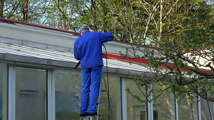 人动力清洗温室屋顶和窗户。