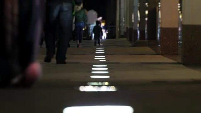 面目全非的人在低路灯延时的灯光下在夜城四处走动。周末的概念家庭之夜