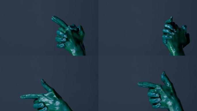 时装模特的双手涂成绿色，用手势和射击显示枪支。时尚视频。