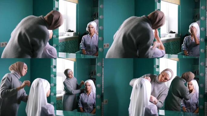 两名穆斯林妇女绑上伊斯兰头巾，准备在镜子附近举行婚礼