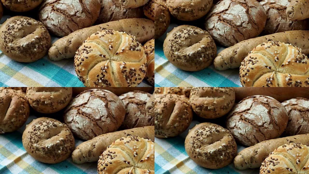 堆满各种面包卷，撒上盐和香菜，芝麻。发酵面团制成的新鲜乡村面包。