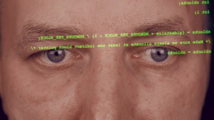 特写男人脸灰色的眼睛。黑客键入代码。屏幕上的绿色类型。网站的程序员编码软件。黑客正在准备对黑客门户进