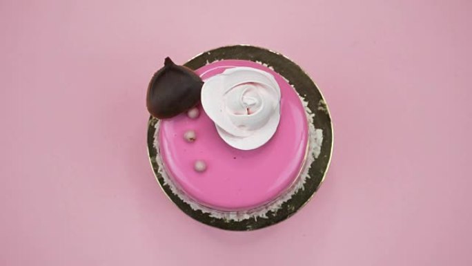 粉色背景上明亮多彩的蛋糕特写。旋转顶视图