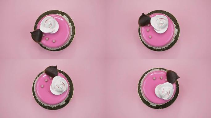 粉色背景上明亮多彩的蛋糕特写。旋转顶视图
