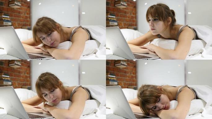 睡觉的女人在床上阅读笔记本电脑上的信息
