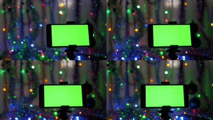 带有绿色屏幕的智能手机，在新年背景上。摄像机在物体周围的运动。