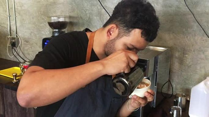 亚洲男咖啡师在咖啡店创作拿铁艺术