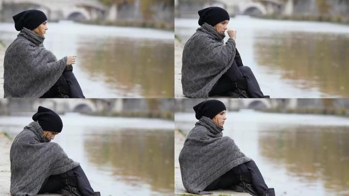 忧郁的女人在寒冷的秋日沿着河边保持悲伤