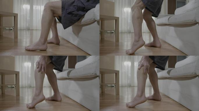 赤脚老人从沙发上站起来时腿部肌肉不适的特写镜头