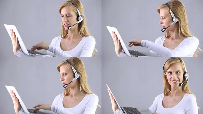 用耳机联系我们女性呼叫中心使用电脑隔离在灰色背景