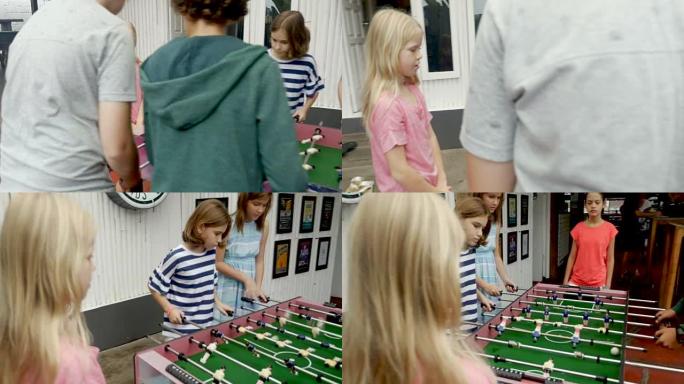 年轻女孩对年轻男孩玩桌上足球