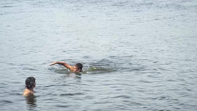 少年在母亲旁边的湖中游泳