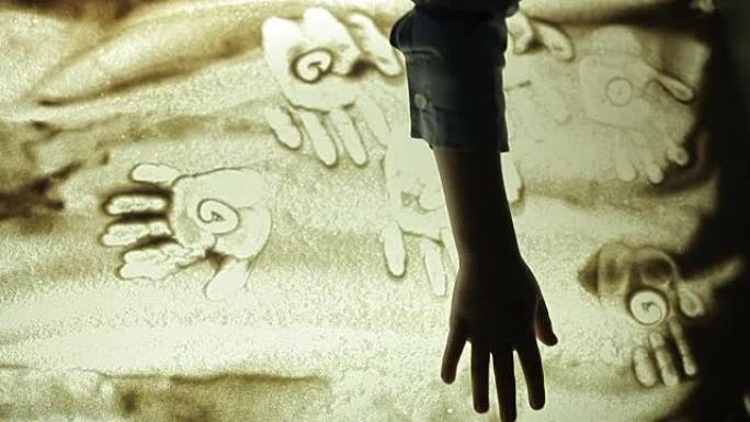 希尔德伦用手在沙滩上画画
