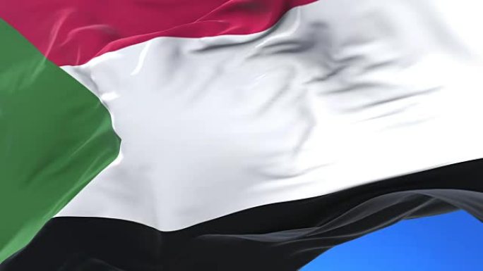 苏丹国旗在蓝天下缓慢地挥舞着，循环