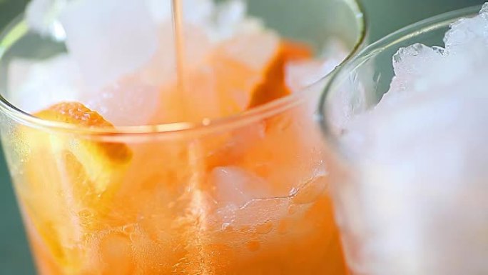 将橙色饮料倒在冰上