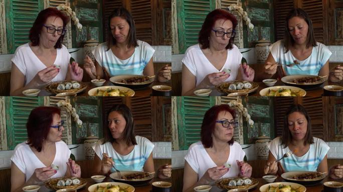 妇女坐在越南餐厅的餐桌旁吃饭和说话