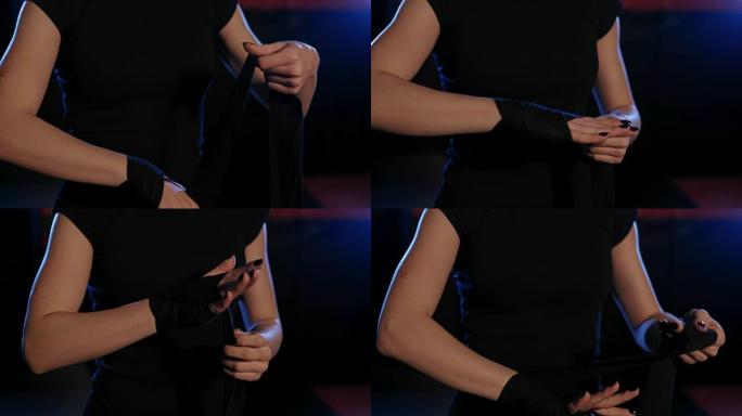 女孩摇动拳击绷带。女人穿上拳击包裹的特写镜头。特写。拳击手在手上摇动特殊的绷带。