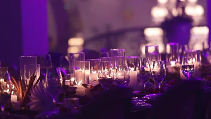 餐桌上的装饰蜡烛，餐桌上的眼镜和圣诞节蜡烛，带玻璃烛台的白蜡烛台，带玻璃烛台的蜡烛，餐厅，室内，特写