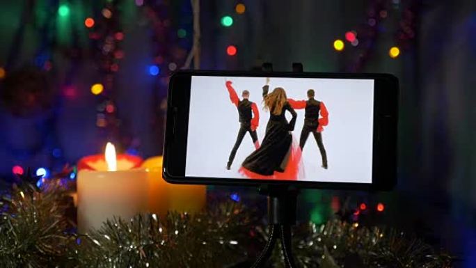 新年背景。在前景是智能手机，其上的视频与艺术家的表现。