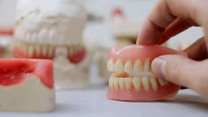 假下巴在牙齿模型的背景下发出咔嗒声