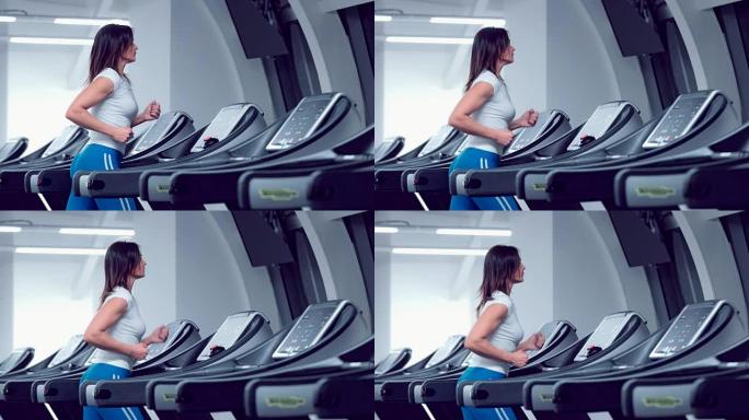 Adult woman runs on treadmill at the fitness centr