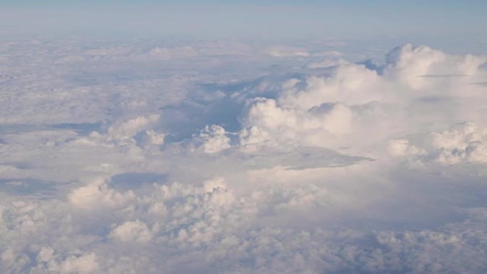 从飞机高空飞行的白色蓬松云上晴朗天空的美丽鸟瞰图