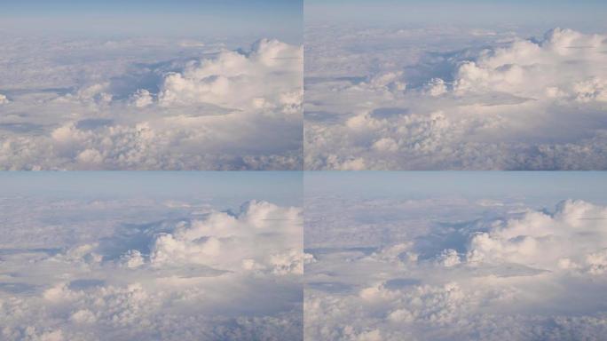从飞机高空飞行的白色蓬松云上晴朗天空的美丽鸟瞰图