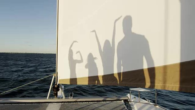 高加索家庭在游艇上玩简单的剪影游戏