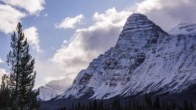 Time lapse of clouds above snowy mountain peaks an