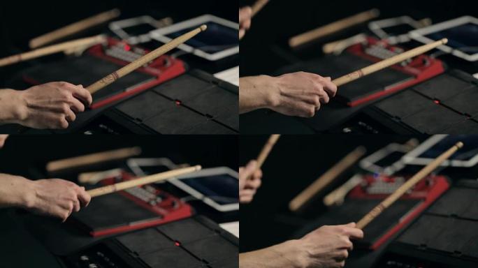 音乐家的手在带有鼓槌的电子垫上演奏
