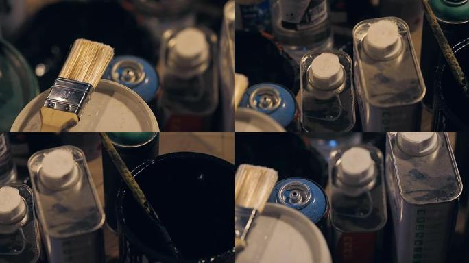 画室里有油漆的刷子和罐子，还有溶剂的罐子。
