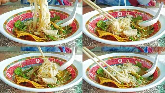 4K，亚洲女人吃鱼面。她吃得津津有味。用棍子吃热的传统中国菜 -- 丹
