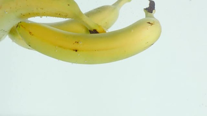 香蕉在慢动作的白色背景下陷入水中