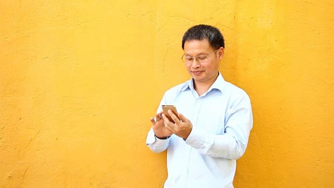 泰国男子玩电话黄墙