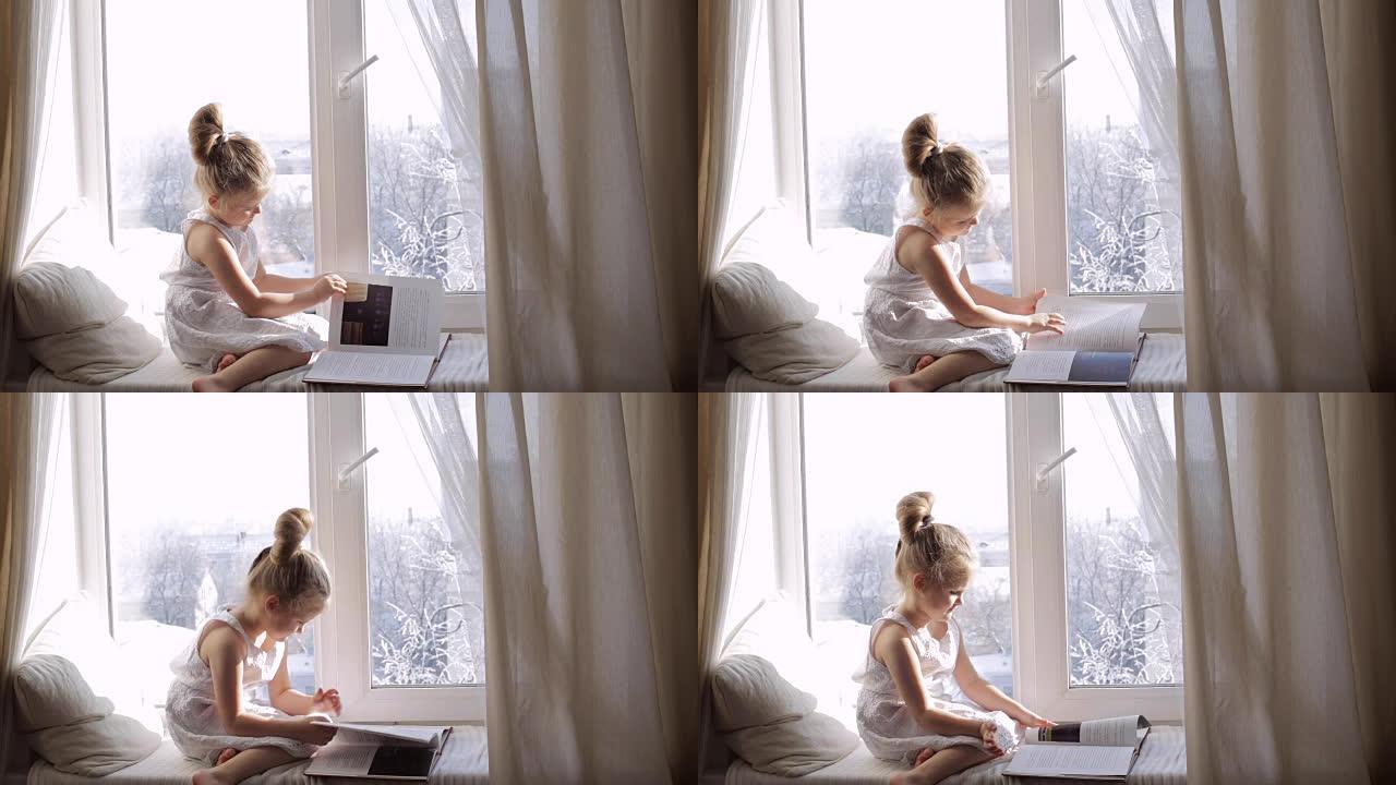 可爱的小女孩，书坐在窗台上。窗外的冬天