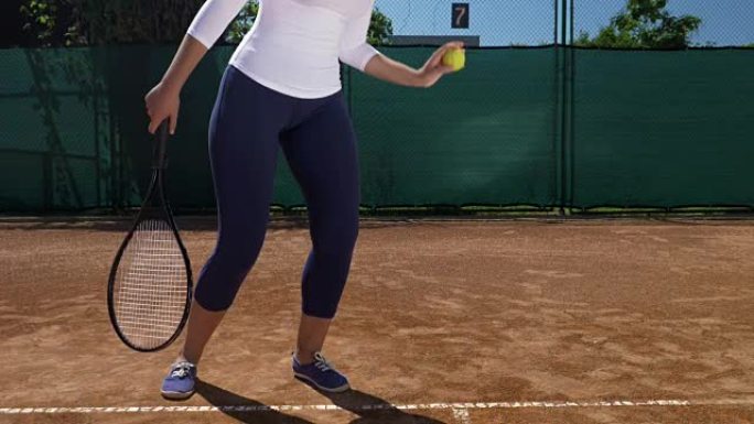 女人手里拿着网球拍，另一只手在煤渣上弹起一个球