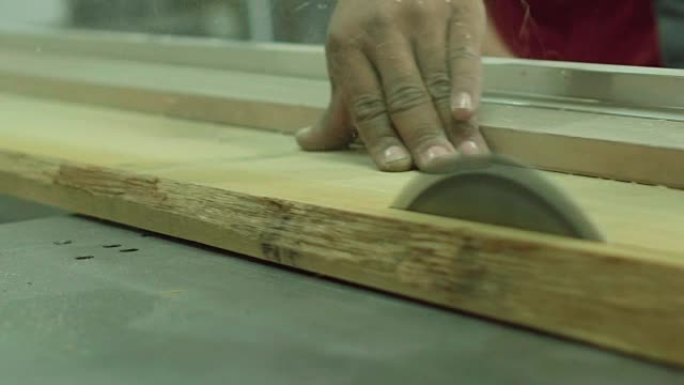 木匠工人用圆锯切割生原木木板