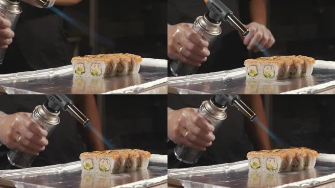 专业寿司厨师在商用厨房准备火卷，特写镜头。