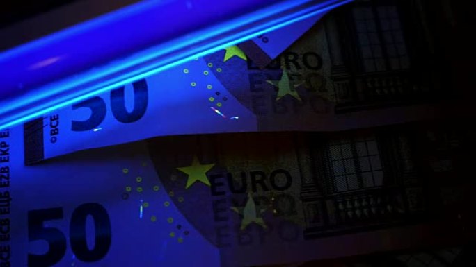 伪钞检测。用紫外线咀嚼欧元纸币。