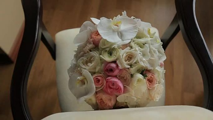 美丽的婚礼花束白色和粉红色的玫瑰躺在古董复古椅子上。