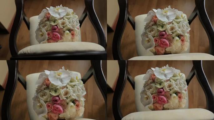 美丽的婚礼花束白色和粉红色的玫瑰躺在古董复古椅子上。