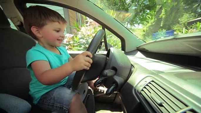 小男孩在一辆大汽车的方向盘后面玩耍