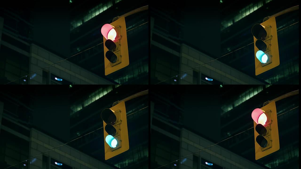 交通信号灯在夜间的摩天大楼背景下工作。延时