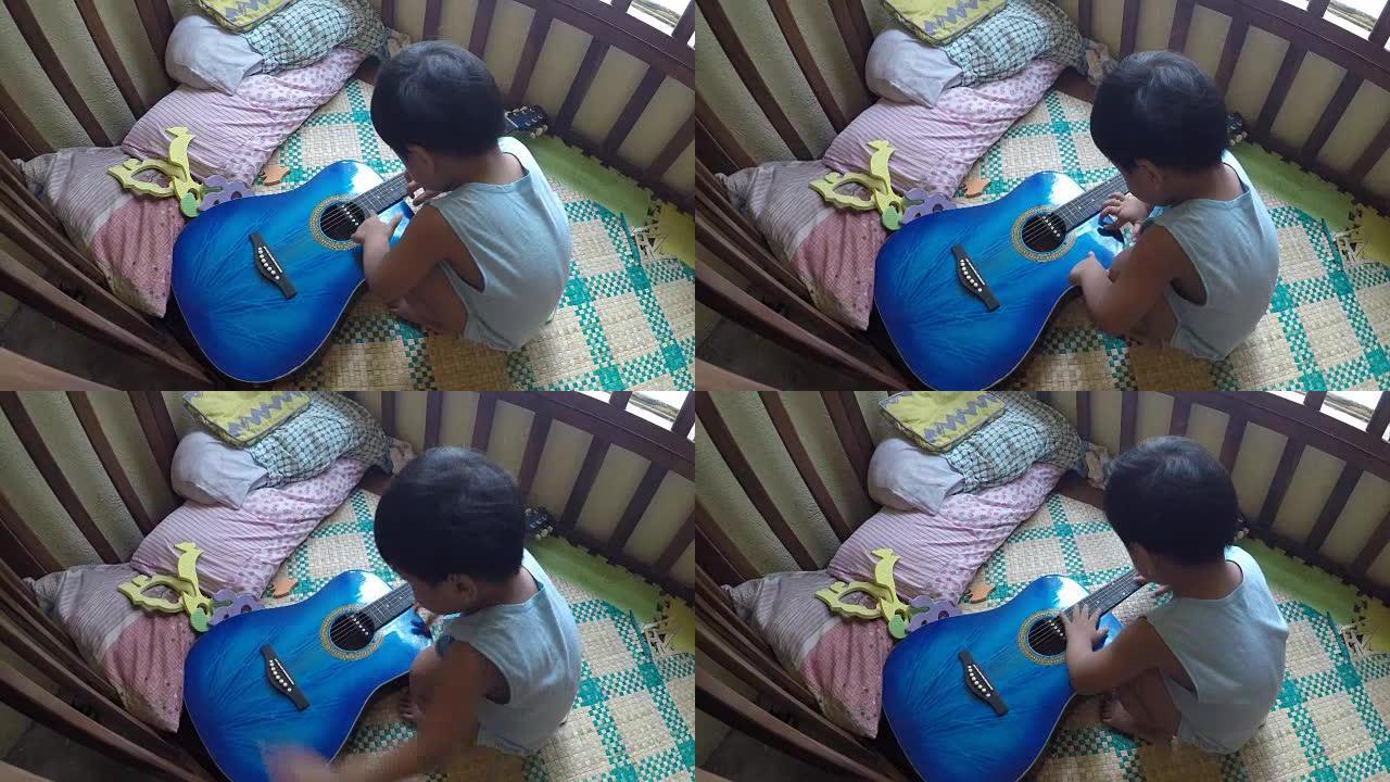两岁的小男孩好奇，在婴儿床里弹吉他