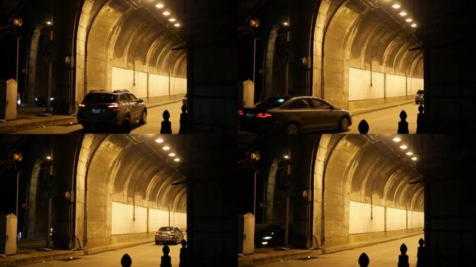 夜间在黑暗的高速公路附近进入城市隧道的汽车