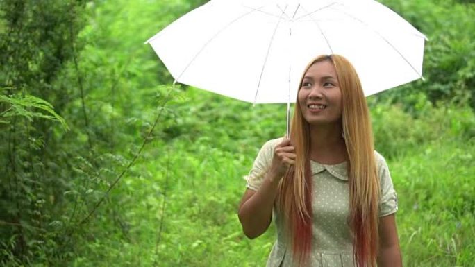 女人在雨下走路手拿着白伞