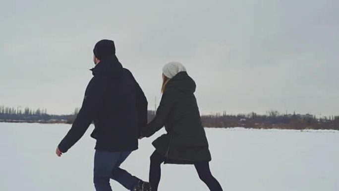 爱在雪地里玩耍的情侣。雪中的男人和女人