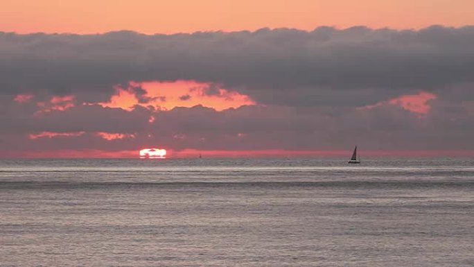 海上地平线上的日落或日出，帆船的轮廓